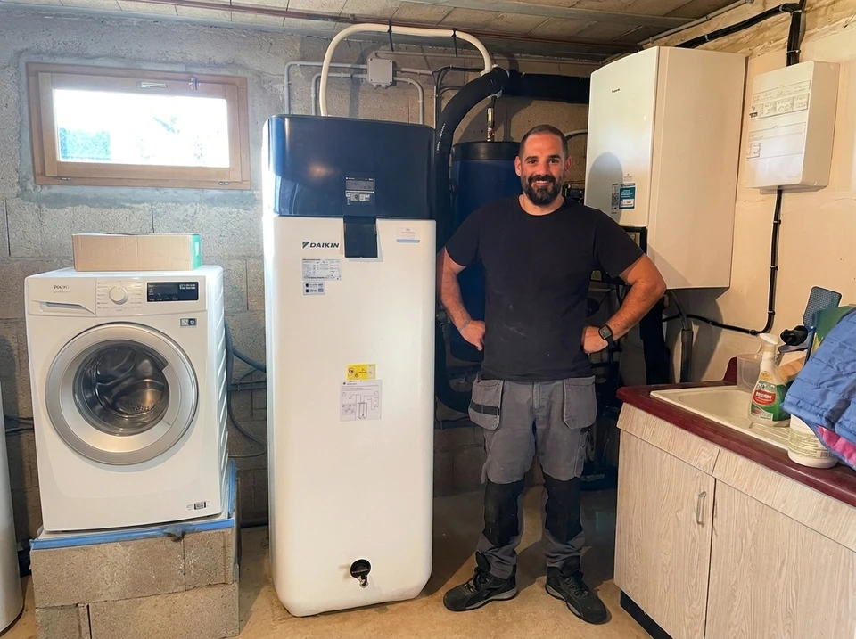 Un technicien travaille à l'entretien d'une unité de climatisation extérieure, à l'aide de divers outils et équipements dans un cadre résidentiel