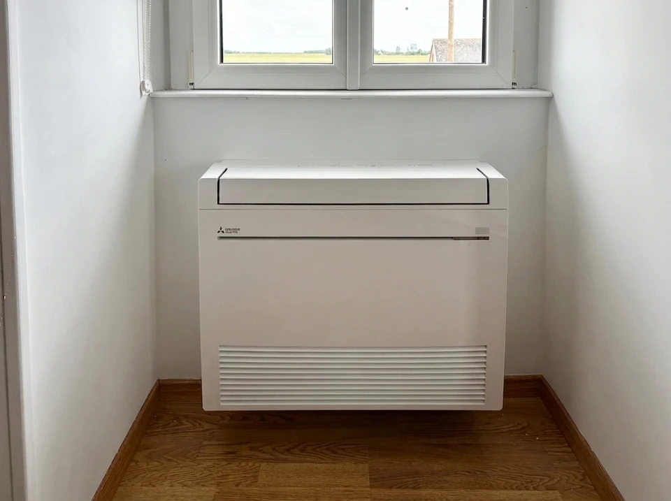 Technicien en climatisation travaillant sur unité extérieure avec manomètres de réfrigération